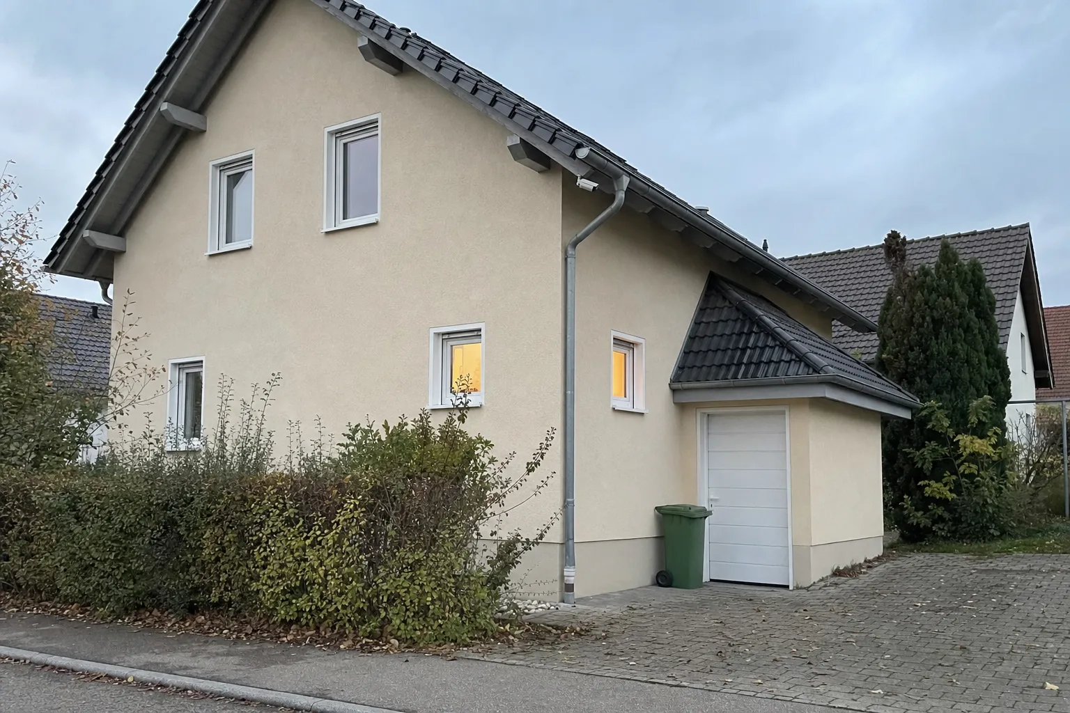 Einfamilienhaus in der Abenddämmerung mit dezent montierter Überwachungskamera